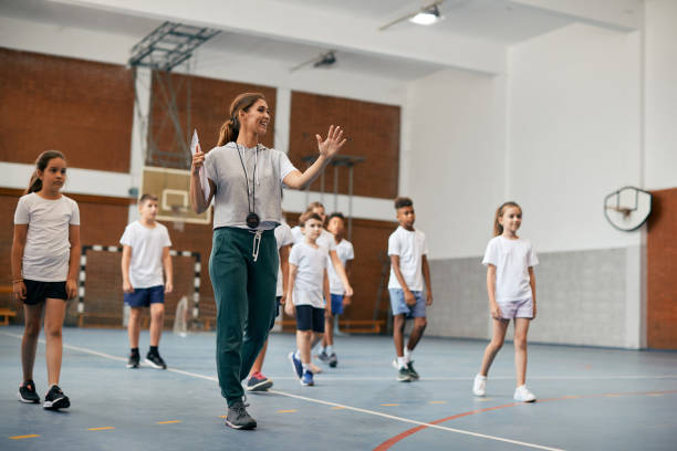 young female coach having pe class with group of elementary